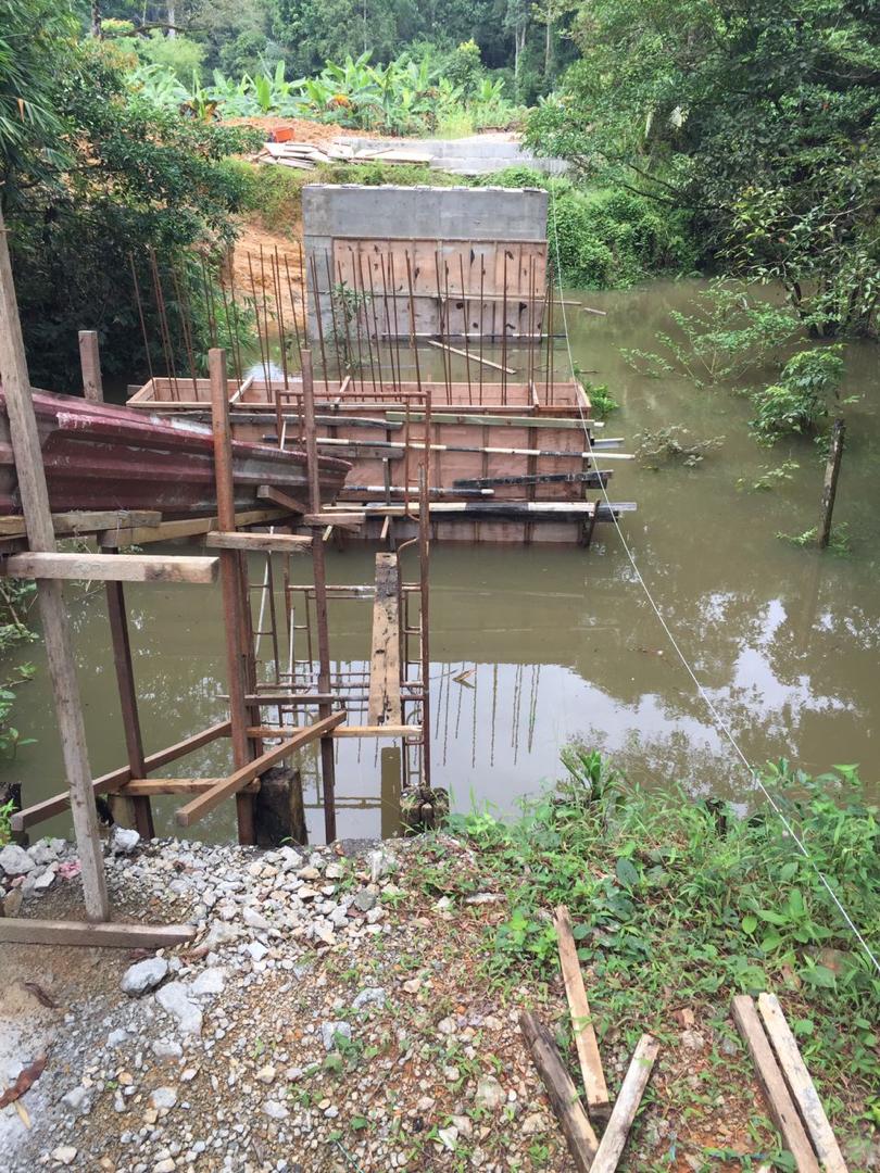 Formwork dan tetulang untuk abutment jambatan Sungai Kuhas yang dicor di tepi sungai yang banjir