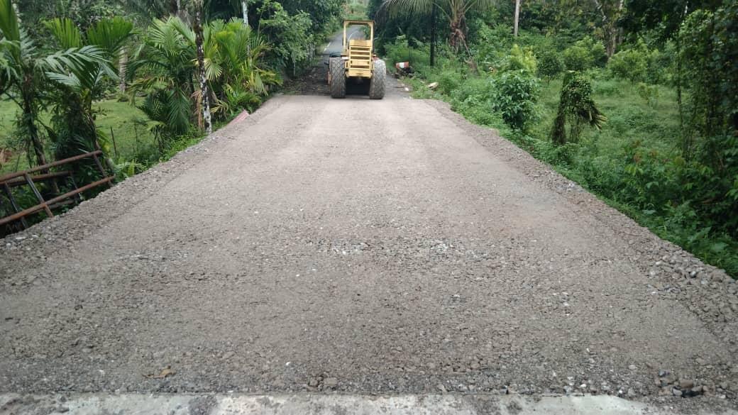 Roller memadatkan asas jalan kelikir di jalan tuju jambatan Sungai Kuhas
