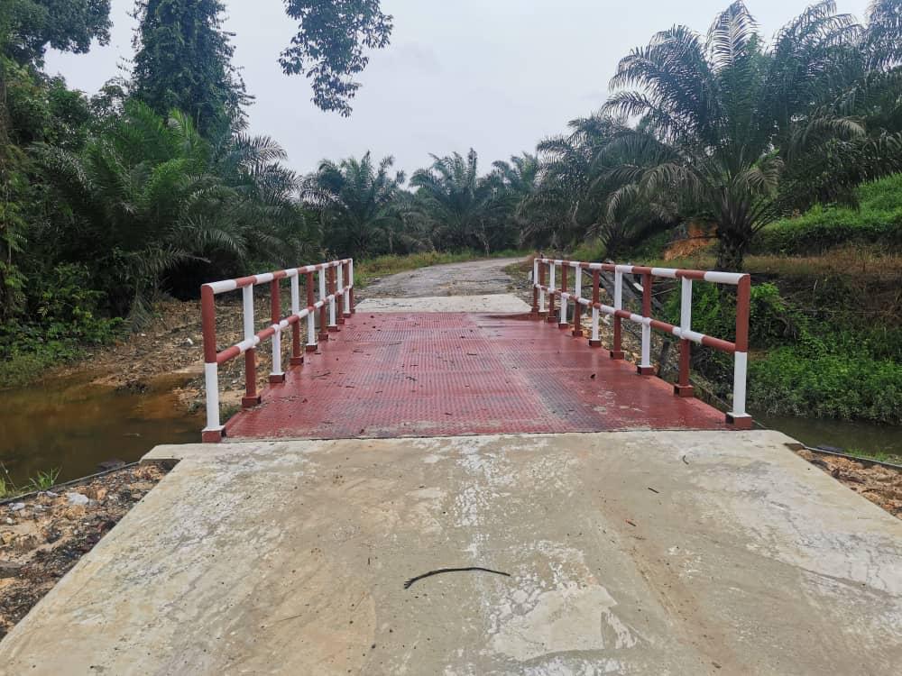 Jambatan Stenggang yang siap dengan pagar keluli merah dan putih merentasi sungai